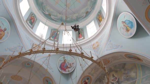 Alpinista industrial em equipamentos para trabalhos de alta altitude trabalhando em alta altitude em um prédio da igreja. Alpinista instalação de alta altitude de um lustre e iluminação. nos mosquetões de cinto de alpinista . — Vídeo de Stock