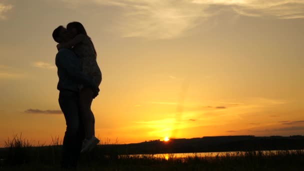 Homem amoroso e mulher dançam em raios brilhantes de sol no fundo do lago. casal dançando ao pôr do sol na praia. Feliz cara e menina valsa à noite no parque de verão . — Vídeo de Stock