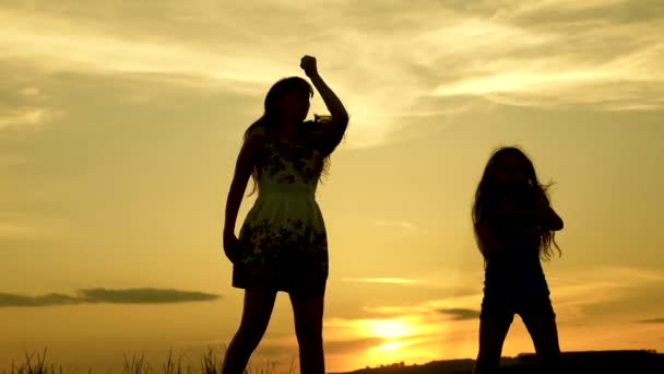 十代のガールフレンド休日ディスコ。湖の前でパーティーをして、子供たちが踊っている。ビーチで踊る幸せな女の子。音楽を聴いて楽しんでいる美しい女の子。姉妹が踊っている. — ストック動画