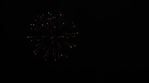 Gloeiende vuurwerk show. gekleurde nachtelijke explosies in de zwarte lucht. mooi multi gekleurd vuurwerk in de nachtelijke hemel. Oudejaarsavond vuurwerk vieren. schijnt vuurwerk met bokeh lichten in de nacht — Stockfoto