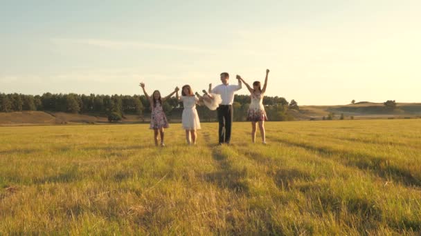 Concept of happy family. Children and mom are playing in meadow. mother and little daughter with sisters walking in park. Happy young family with a child walking on summer field. happy family concept. — Stock Video