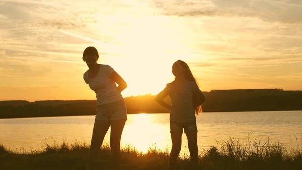 Happy girls dancing on the beach. party by the lake, children dancing. beautiful girls having fun listening to music. sisters are dancing. teens girlfriends holiday disco. — Stock Photo, Image