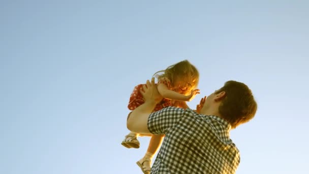 Mutlu çocukluk kavramı. Babam mavi gökyüzüne mutlu bir kız çocuğu fırlatıyor. Mutlu aile yolculukları. Baba ve küçük çocuk birlikte oynuyorlar, gülüyorlar ve sarılıyorlar. Bebeğin ebeveynin kollarında. Mutlu aile kavramı — Stok video