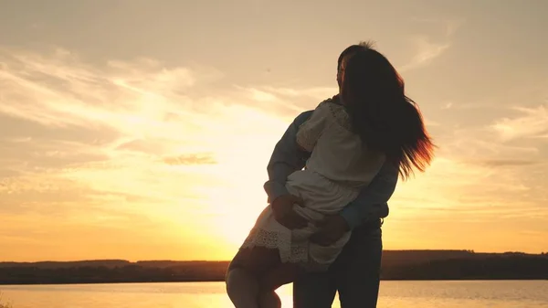 Ragazzo felice e ragazza valzer la sera nel parco estivo. Amare l'uomo e la donna danzano in raggi di sole sullo sfondo del lago. Giovane coppia che balla al tramonto sulla spiaggia . — Foto Stock
