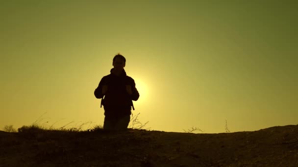 Silhouetten van alpinist gaan bergop. reizigers beklimmen de heuvel in de stralen van de zon een voor een. toeristen reizen met rugzakken. teamwork van zakenmensen. business team heeft haast om te winnen en te slagen. — Stockvideo