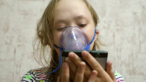 Dziecko z tabletką jest chore i oddycha przez inhalator. zbliżenie. Dziewczynka leczona maską inhalacyjną na twarzy w szpitalu. Maluch leczy grypę poprzez wdychanie oparów wziewnych. — Wideo stockowe