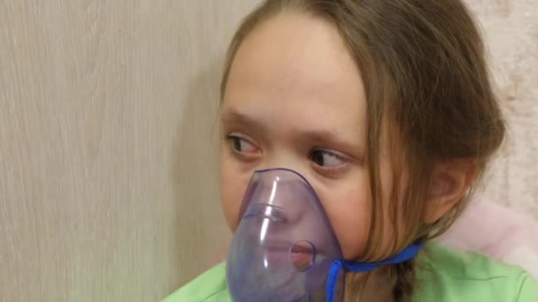 Bambino con compressa è malato e respira attraverso un inalatore. primo piano. bambina trattata con una maschera per inalazione sul viso in ospedale. Il bambino tratta l'influenza inalando vapore per inalazione . — Video Stock