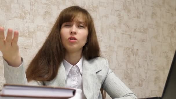 Женщина на рабочем месте разговаривает с клиентом в офисе. перегруженный работой работник в офисе. работающая молодая предпринимательница . — стоковое видео