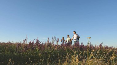 Turistlerin takım çalışması. Gezginler sırt çantalarıyla çayıra giderler. Kırsalda çocuklu bir turist ailesi. Gezginler güzel manzaraya ve doğaya hayran kalırlar. Zafere giden yol.
