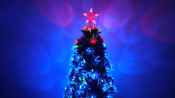 Beautiful Christmas tree in room, decorated with a luminous garland and star. New Year 2020 mood. Christmas tree, happy holidays. Christmas interior. holiday for children and adults. — Stock Video