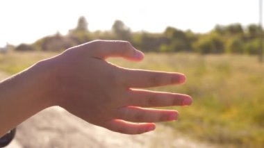 Uzun saçlı kız önünde araba koltuğunda oturan, kolunu pencereden dışarı uzanan ve parlama güneş kurma yakalamak