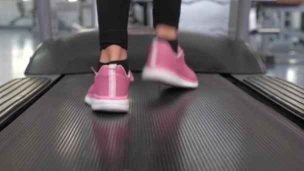 Kaki gadis dengan sepatu olahraga pergi bersama treadmill. close-up. Memperkuat otot kaki saat berjalan. beban kardio. Wanita klub kebugaran pergi jalan-jalan. Konsep gaya hidup olahraga. penurunan berat badan di gym . — Stok Video