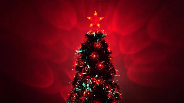 Schöner Weihnachtsbaum im Zimmer, geschmückt mit einer leuchtenden Girlande und einem Stern. Neujahrsstimmung 2020. Weihnachtsbaum, frohe Feiertage. Weihnachtsinterieur. Urlaub für Kinder und Erwachsene. — Stockfoto
