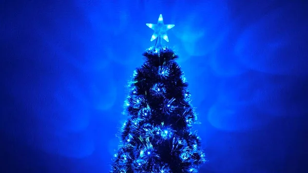 Gyönyörű karácsonyfa a szobában, díszített egy fényes koszorú és csillag. Újév 2020 hangulat. Karácsonyfa, boldog ünnepeket. Karácsonyi belső. nyaralás gyermekek és felnőttek számára. — Stock Fotó