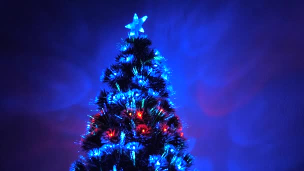 Odada parlak bir çelenk ve yıldızla süslenmiş güzel bir Noel ağacı var. Çocuklar ve yetişkinler için tatil. Yeni yıl 2020 havası. Noel ağacı, mutlu tatiller. Noel arşivi. — Stok video