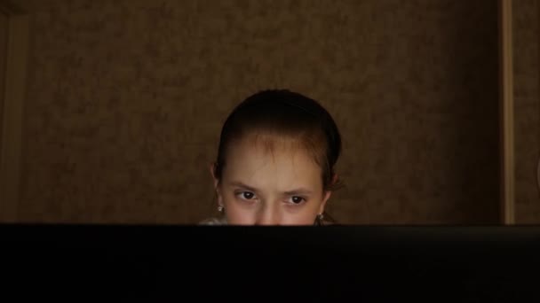 疲れた十代の少女は、ノートパソコンのモニターの画面に見えます。クローズ アップ。若い女の子は、夜に彼女の部屋に疲れた目でコンピュータの画面を見てください。疲れた十代の少女は、ノートパソコンのモニターの画面に見えます. — ストック動画
