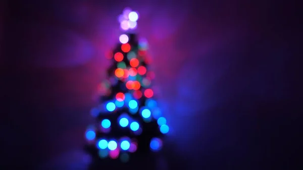 Sokszínű bokeh egy újévi fa a szobában, díszített fényes koszorú és egy csillag. nyaralás gyermekek és felnőttek számára. Újév. Karácsonyfa, boldog ünnepeket. Karácsonyi belső. — Stock Fotó