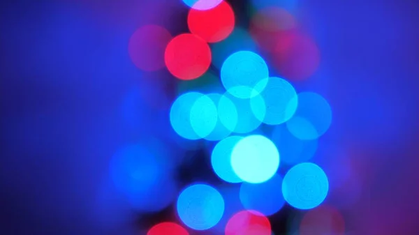 Schöne mehrfarbige Bokeh eines Weihnachtsbaums im Zimmer, dekoriert mit einem leuchtenden Kranz und einem Stern. Urlaub für Kinder und Erwachsene. Neujahr. Weihnachtsbaum, frohe Feiertage. Weihnachtsdekoration. — Stockfoto