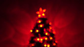 pestrobarevný bokeh novoroční stromeček v místnosti, zdobený zářivým věncem a hvězdou. dovolená pro děti i dospělé. Nový rok. Vánoční stromek, veselé svátky. Vánoční interiér.