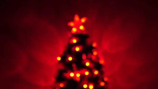 Mehrfarbiges Bokeh eines Neujahrsbaumes im Raum, dekoriert mit leuchtenden Girlanden und einem Stern. Urlaub für Kinder und Erwachsene. Neujahr. Weihnachtsbaum, frohe Feiertage. Weihnachtsdekoration. — Stockfoto