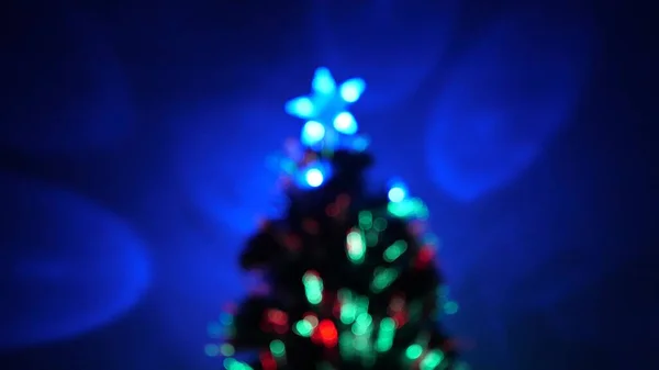 Bokeh multicor de uma árvore de Ano Novo no quarto, decorado com guirlanda luminosa e uma estrela. férias para crianças e adultos. Ano Novo. Árvore de Natal, boas festas. Interior de Natal . — Fotografia de Stock