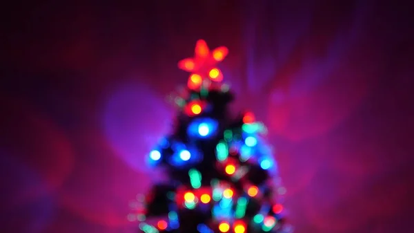 Bokeh multicor de uma árvore de Ano Novo no quarto, decorado com guirlanda luminosa e uma estrela. férias para crianças e adultos. Ano Novo. Árvore de Natal, boas festas. Interior de Natal . — Fotografia de Stock