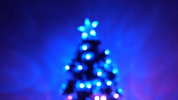 Bokeh multicolor de un árbol de Año Nuevo en la habitación, decorado con guirnalda luminosa y una estrella. vacaciones para niños y adultos. Año Nuevo. Árbol de Navidad, felices fiestas. Interior de Navidad . — Foto de Stock