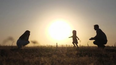 Ebeveynler küçük kızları ile oynarlar. anne ve baba güneşte kızları ile oynamak. mutlu bebek babadan anneye geçer. genç aile alanında bir çocuk 1 yıl. aile mutluluğu kavramı.