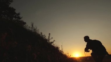 macera ve seyahat konsepti. Turistler gün batımında el ele tutuşarak dağdan iner. Erkek gezgin, tepeden inen bir kadın yolcunun elini tutuyor. iş adamlarının takım çalışması.