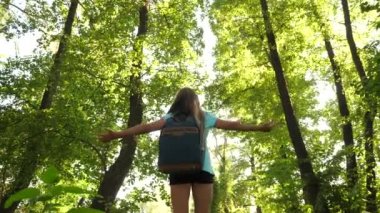 Yürüyüş yapan kadın ormanda yürüyor. Kız gezgin sırt çantasıyla ormanda yürüyor. Yaz parkındaki mutlu yürüyüşçü kız. Genç kız tatilde maceralar yaşıyor. Gezgin uçuşta pilot olmayı hayal eder.