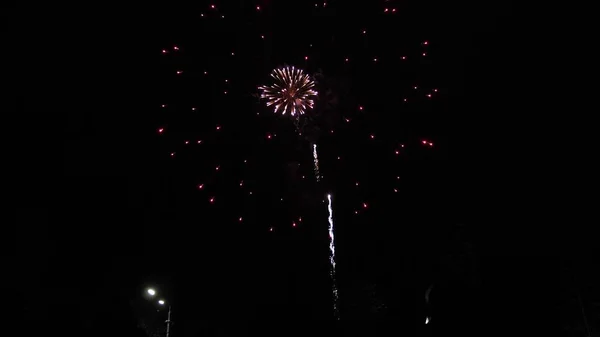 Glowing fireworks show. colored night explosions in black sky. beautiful multi colored fireworks in night sky. New years eve fireworks celebration. shining fireworks with bokeh lights in the night — Stock Photo, Image