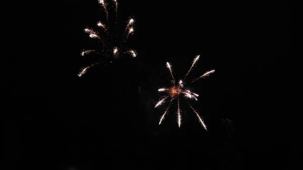 Glühendes Feuerwerk. Farbige nächtliche Explosionen am schwarzen Himmel. schönes mehrfarbiges Feuerwerk am Nachthimmel. Silvesterfeuerwerk. leuchtendes Feuerwerk mit Bokeh-Lichtern in der Nacht — Stockfoto