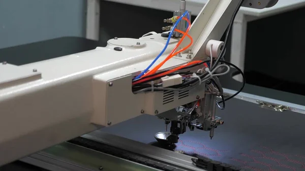 Máquina de coser ordenador de control. máquina de coser automática. Bordado a máquina automatizado. La robótica CNC trabaja en la línea de producción de costura. Máquina de coser robot . — Foto de Stock