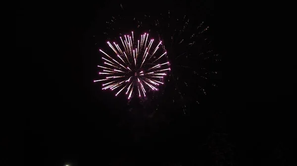 Espectáculo de fuegos artificiales brillantes. explosiones nocturnas de color en el cielo negro. hermosos fuegos artificiales multicolores en el cielo nocturno. Año nuevo víspera de celebración de fuegos artificiales. fuegos artificiales brillantes con luces bokeh en la noche — Foto de Stock