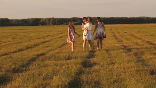 Les enfants et maman jouent dans la prairie. concept d'une famille heureuse. mère et petite fille avec des sœurs marchant dans le parc. Joyeux jeune famille avec un enfant marchant sur un champ d'été . — Video