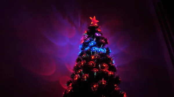 Schöner Weihnachtsbaum im Zimmer, geschmückt mit einem leuchtenden Kranz und einem Stern. Urlaub für Kinder und Erwachsene. Neujahr. Weihnachtsbaum, frohe Feiertage. Weihnachtsdekoration. — Stockfoto