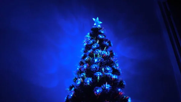 房间里美丽的圣诞树，装饰着明亮的花环和一颗星星。 儿童和成年人的假日。 新年。 圣诞树，节日快乐。 圣诞内部. — 图库照片