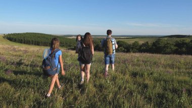 Gezginler güzel manzaraya ve doğaya hayran kalırlar. Turistlerin takım çalışması. Gezginler sırt çantalarıyla çayıra giderler. Kırsalda çocuklu bir turist ailesi. Zafere giden yol.