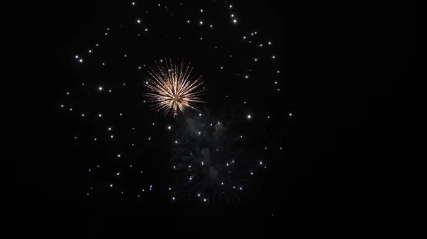 Mooi multi gekleurd vuurwerk in de nachtelijke hemel. Oudejaarsavond vuurwerk vieren. Schijnend vuurwerk met bokeh lichten aan de nachtelijke hemel. gloeiende vuurwerk show. gekleurde nacht explosies in zwarte lucht — Stockfoto