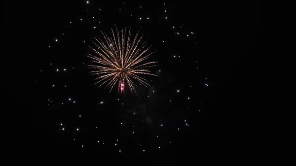 Όμορφα πολύχρωμα πυροτεχνήματα στο νυχτερινό ουρανό. Πρωτοχρονιάτικα πυροτεχνήματα. Λαμπερά πυροτεχνήματα με φώτα bokeh στο νυχτερινό ουρανό. Λαμπερό σόου πυροτεχνημάτων. χρωματιστές εκρήξεις νύχτας στον μαύρο ουρανό — Φωτογραφία Αρχείου