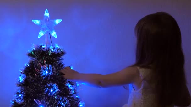 Niña feliz está jugando junto al árbol de Navidad. vacaciones para niños y adultos. Año Nuevo. Árbol de Navidad, felices fiestas. Interior de Navidad . — Vídeo de stock