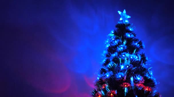 Hermoso árbol de Navidad en la habitación, decorado con una guirnalda luminosa y una estrella. vacaciones para niños y adultos. Año Nuevo 2020 estado de ánimo. Árbol de Navidad, felices fiestas. Interior de Navidad . — Vídeos de Stock