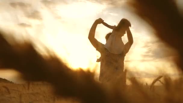 Happy child and dad are playing on the wheat field. happy family and childhood concept. Slow motion. little daughter on fathers shoulders. baby boy and dad travel on a wheat field. — Stock Video