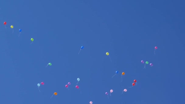 Krásné barevné balónky létají na obloze, červená modrá žlutá oranžová růžová. Ve vzduchu létá mnoho barevných balónků. Oslava a narozeninová koncepce. Koncept krásné dovolené. — Stock video