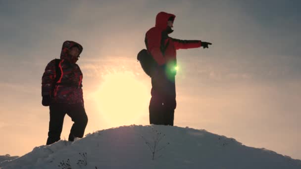 雪の山の旅行者は地形によって導かれ、動きの方向を選択します。アラスカの旅行者は雪の丘の上に行く。人々のチームの仕事ビジネスのチームワーク勝利成功. — ストック動画