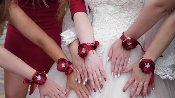 Belle mani della sposa e damigelle d'onore. Festa di nozze. le mani delle ragazze sono decorate con fiori rossi. ragazze di moda — Foto Stock