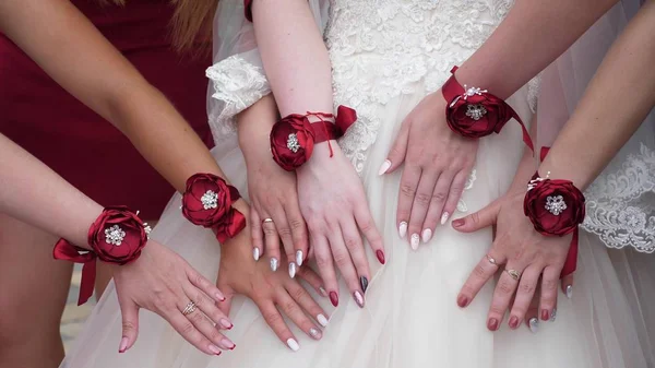 Belle mani della sposa e damigelle d'onore. Festa di nozze. le mani delle ragazze sono decorate con fiori rossi. ragazze di moda — Foto Stock