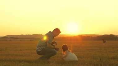 Çocuk babasıyla çayırda çiçek topluyor. Küçük kız babasıyla çayırda el ele tutuşarak yürüyor. Çocuk babasının elini tutuyor. Aile akşam şehir dışına çıkar. Baba ve bebek parkta..