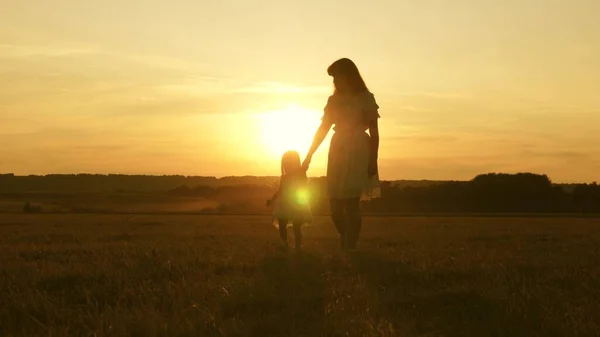 Concept van een gelukkige jeugd. kindmoeder spelen in de weide in de zon. Moeder en dochtertje lopen in een veld in de zon. Gelukkige jonge familie. concept van een gelukkig gezin. — Stockfoto