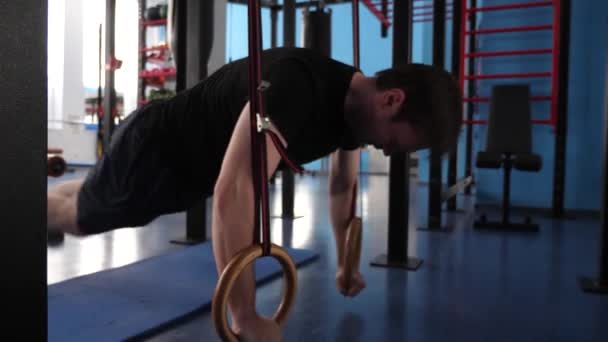 Een man traint in de sportschool. Een sporter trainen, de spieren van de buik trainen, voor kracht en uithoudingsvermogen. voorbereiding van de wedstrijd — Stockvideo